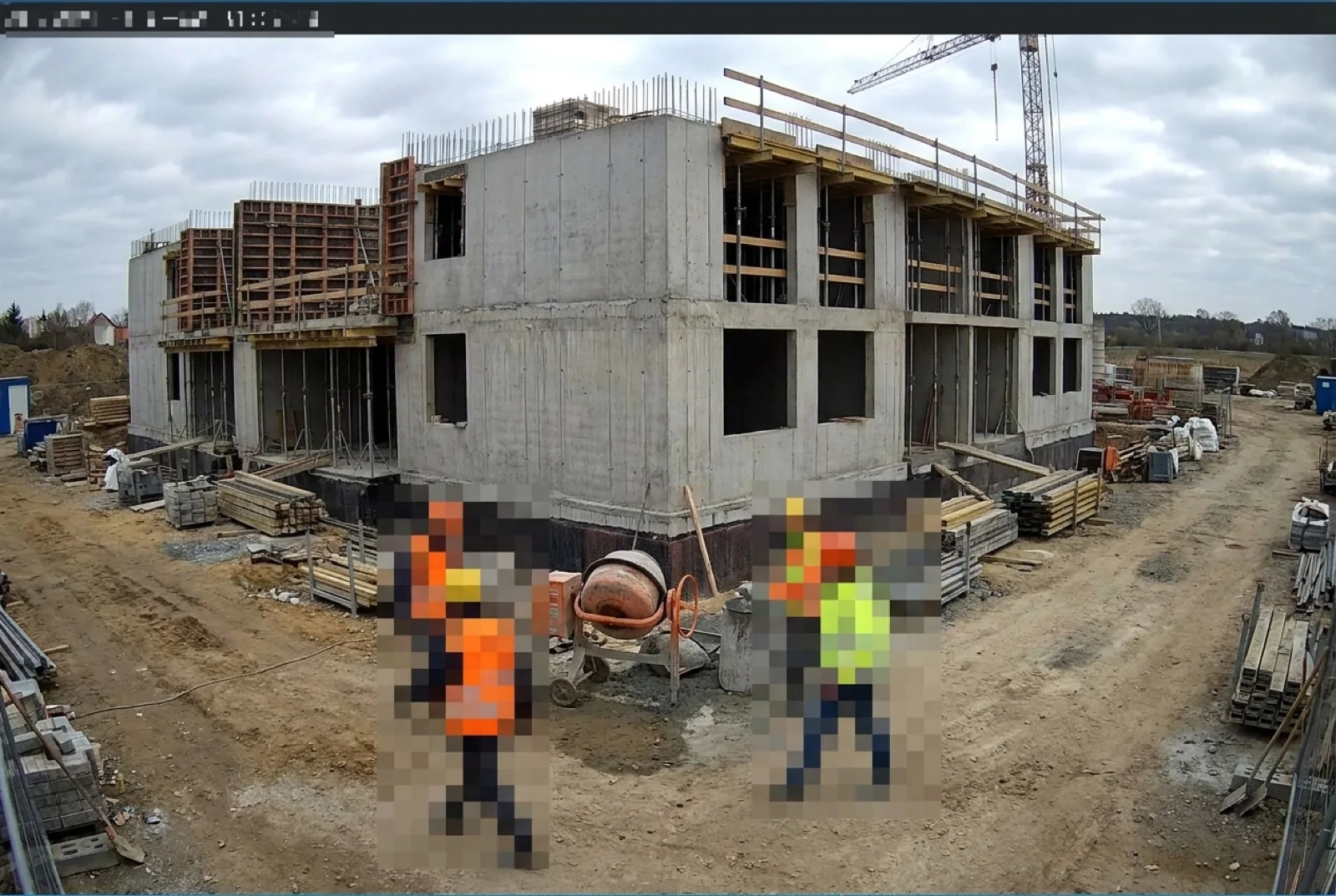 Kamerabild einer Baustelle bei Tag: zwei Personen in Warnweste sind großflächig verpixelt, die Baustelle selbst bleibt scharf.