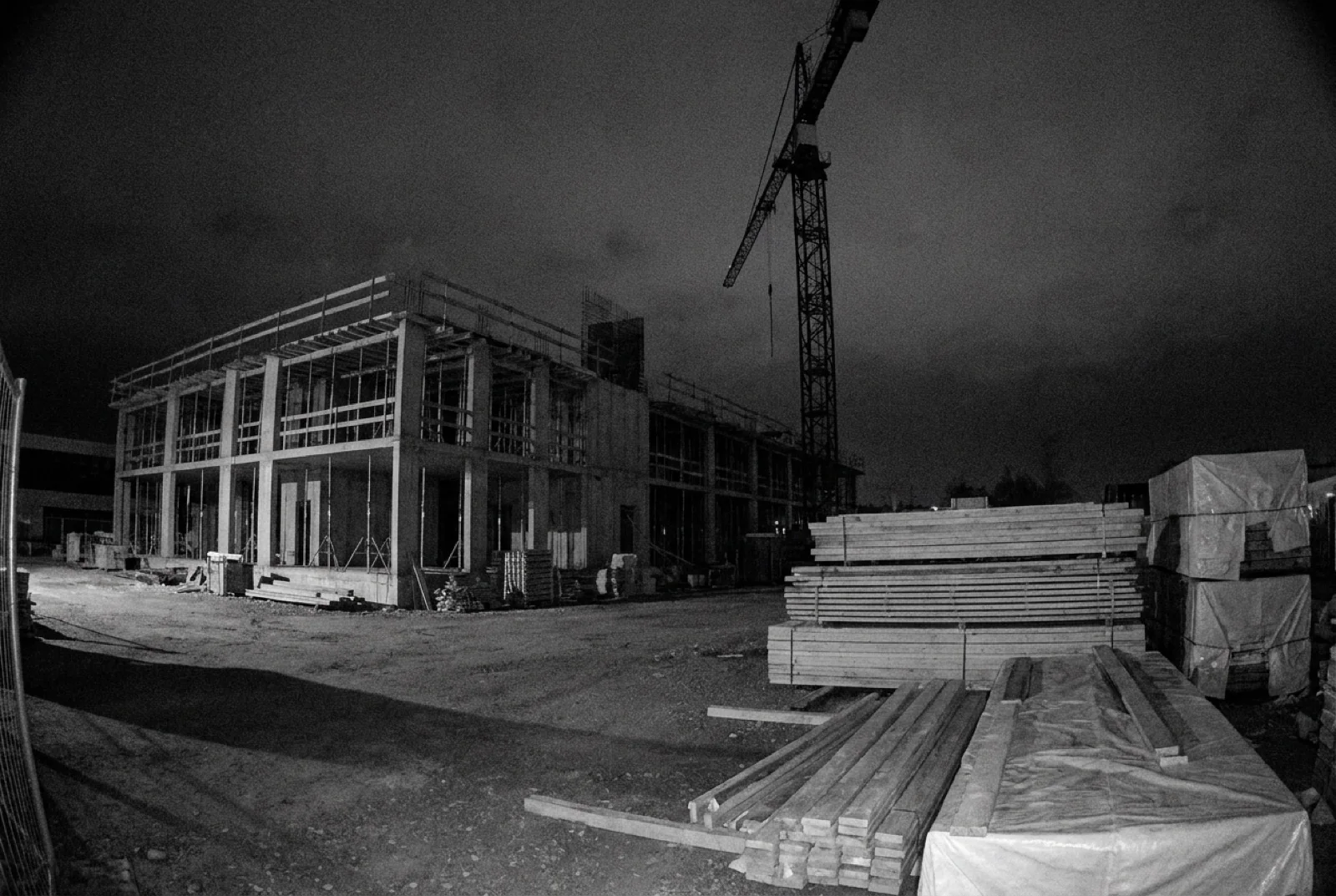 Infrarot-Kamerabild derselben Baustelle bei Nacht, menschenleer, mit Kran-Silhouette.